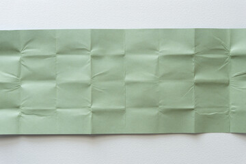 pale green paper sheets folded and arranged flat on paper