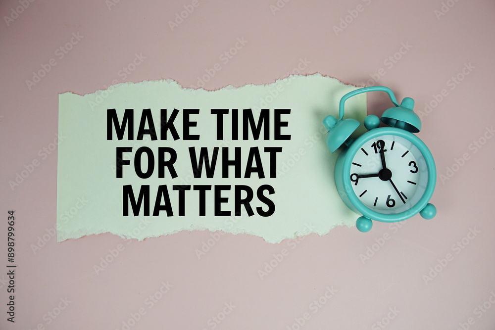 Poster make time for what matters quotes text on paper torn with alarm clock top view on pink background