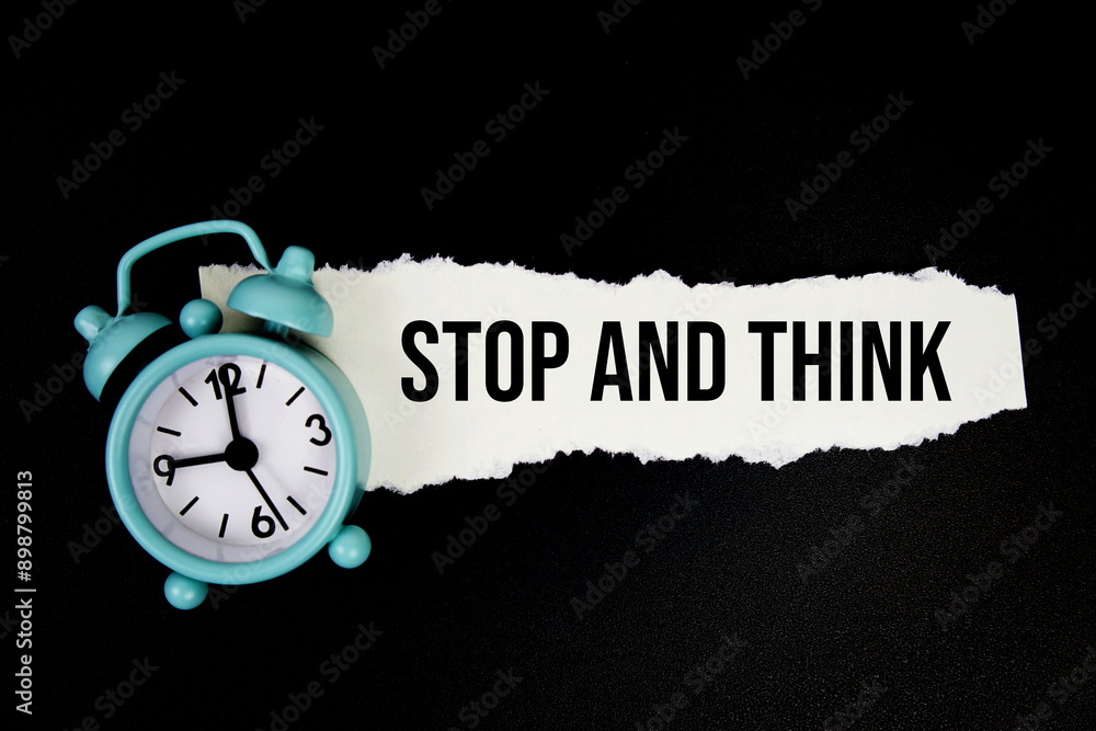Poster stop and think quotes text on paper torn with alarm clock top view on black background