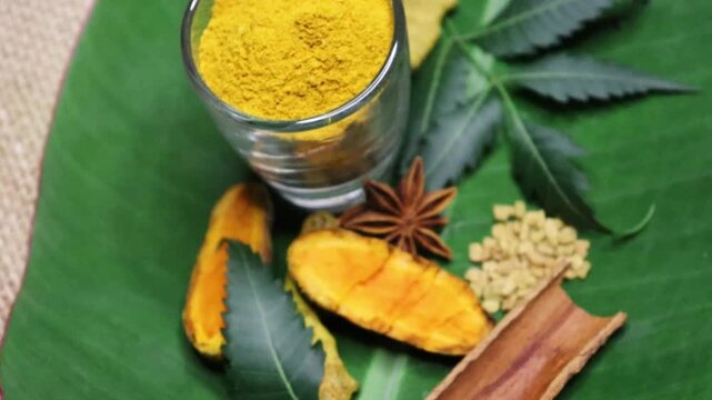 Turmeric root, turmeric powder, neem, black cumin, anise in banana leaf background as medicinal and cooking concept. 4k footage. Indian Spice display. 