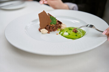 Young woman tasting salad in luxury restaurant, close up