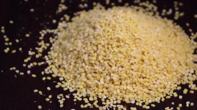 Peeled yellow lentils or moong dal close-up pan view in a pile. 4k. Selective focus. 