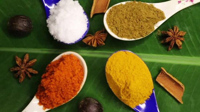 Pan close view of various spices and salt in spoons for cooking on the table. Background for the cafe and restaurant menus, post. 4k. Turmeric, red chili, cumin and coriander power with salt in spoon.