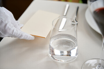 Waiter giving a bill or check for customer to pay money in restaurant