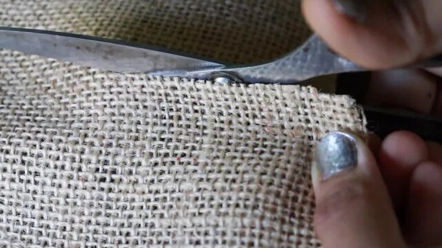 Jute fabric cutting by scissors. close-up. 4k. Jute braided fabric. 