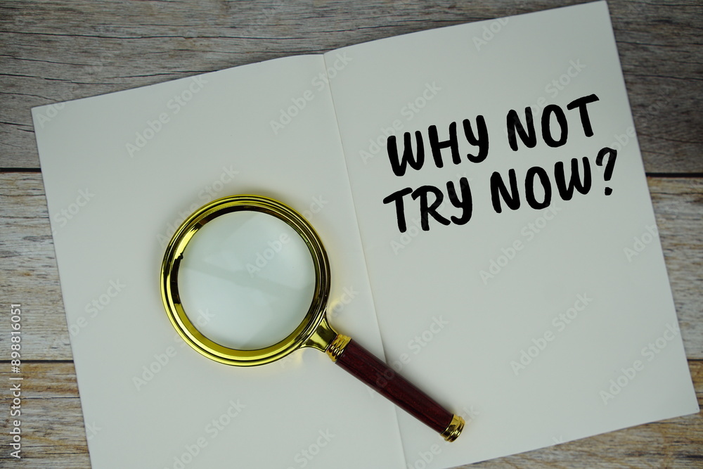 Aufkleber why not try now? text on note page with magnifying glass top view on wooden background