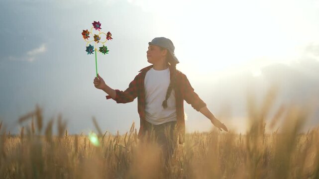 Happy child with pinwheel silhouette. Happy Child runs with pinwheel in hand expressing joy. Joyful child silhouette holding pinwheel. Carefree child playing outdoors silhouette. joy with pinwheel.