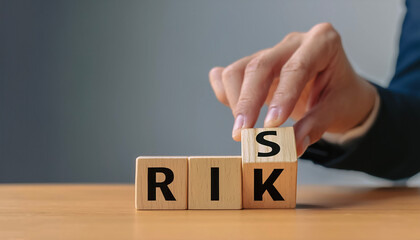 Naklejka premium Risk management concept. Businessman hand put risk word on wooden block cube for financial banking analysis and business management.