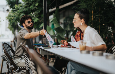 Young professionals having a business meeting outdoors at a cafe. They are discussing documents and enjoying coffee in a relaxed environment.