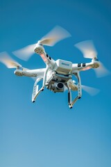 Naklejka premium Aerial view of a white drone soaring through a clear blue sky, great for use in travel or technology concepts