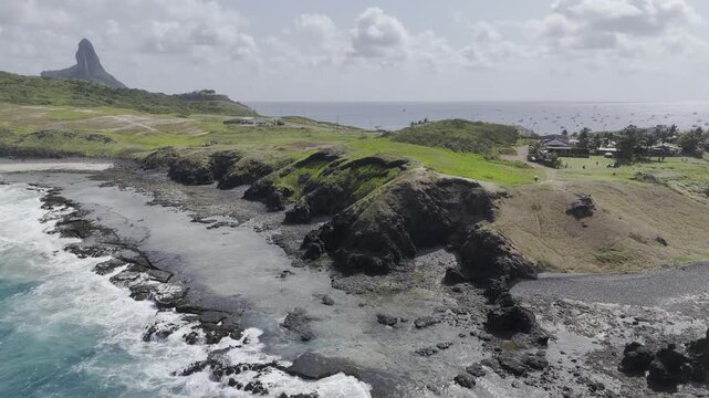 Drone flies up and away from Mirante Buraco da Raquel to reveal a panoramic view of Morro do Pico, Porto Santo Antonio full of boats, Praia Caieiras, and Enseada dos Tubar&otilde;es