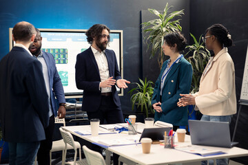 Group of corporate employees are meeting in a boardroom office, debating possible business deals or global collaborations. Coworkers starting a briefing session to share visions and ideas.