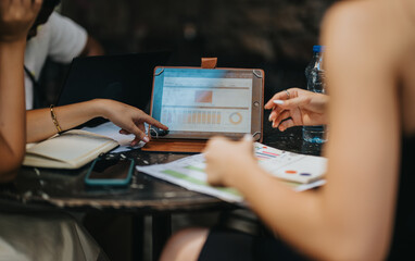 International business professionals engaged in a meeting, analyzing financial reports and marketing strategies to boost profitability and growth.