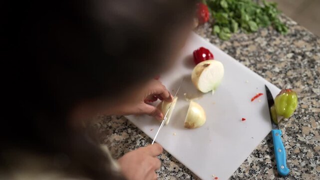 Mujer cortando cebolla con cuchillo en sus manos en la cocina en c&aacute;mara lenta