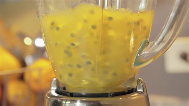 Preparando bebida liquida de jugo de maracuy&aacute; en licuadora girando en vaso de vidrio en camara lenta