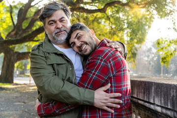Fototapeta premium A smiling married gay couple embracing while looking at the camera.