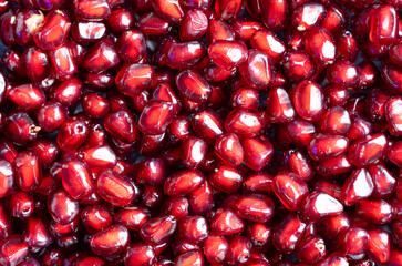 Macrophotography of several red pomegranate berries seen from the top