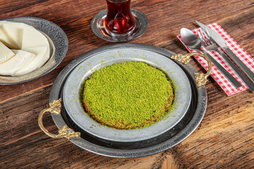 Turkish dessert kunefe, kunafa, kadayif with pistachio powder and cheese, served hot, very sweet....