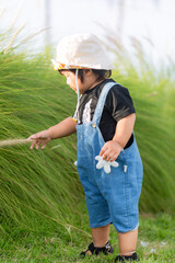 Toddler taking a walk in the green meadow,Toddler taking first steps in a park 