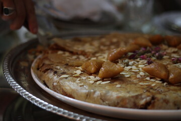 A close-up of a man hand cutting the moroccan Pastilla.