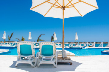 beach chairs and umbrellas on the pool Summer vibes relaxing vacation time out