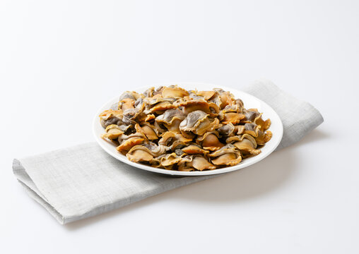 Close-up of stacked boiled cockle flesh on white dish, South Korea
