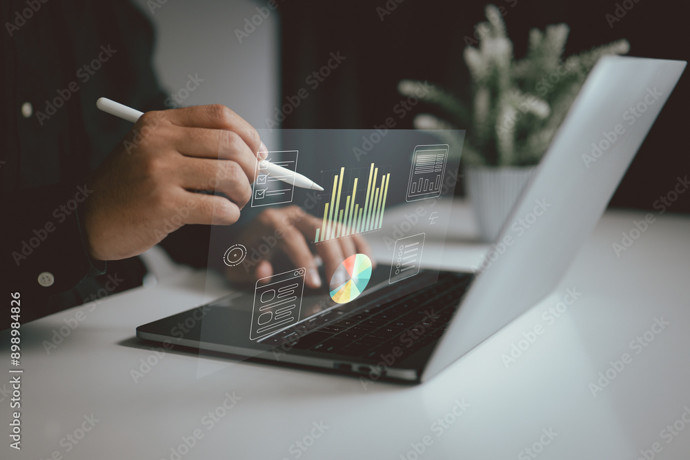 Fototapete Person using a stylus on a laptop with floating charts and data visualizations. It represents the use of digital tools for data analysis, business intelligence in a modern work environment.