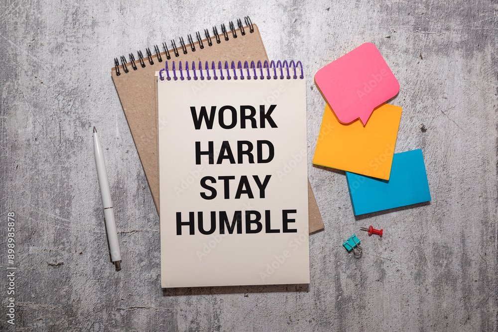 Poster work hard stay humble text concept write on a notebook