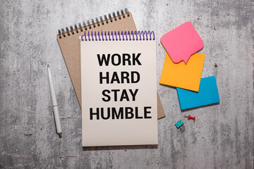 WORK HARD STAY HUMBLE text concept write on a notebook