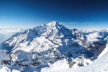 Obraz premium A person standing on the summit of a snow-covered mountain, with breathtaking views