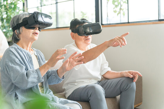 VRゴーグルをつけてバーチャルリアリティ・メタバースを体験するシニア世代の夫婦