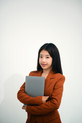 Fototapeta premium Young beautiful Asian woman in business office standing use tablet in hand, Thai girl enjoy browsing for online shopping store with copy space for advertisement, on isolated white background
