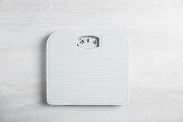One bathroom scale on white wooden background, top view