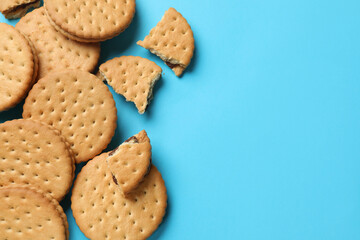 Tasty sandwich cookies on light blue background, top view. Space for text