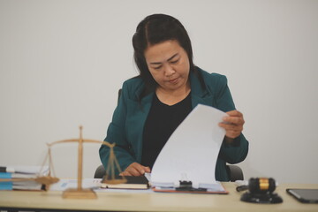 Pretty Asian female lawyer working and hammer, laptop, justice advice and legal concept. In office