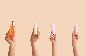 Female hands with different cosmetic products on beige background