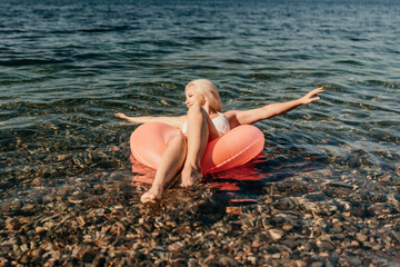 A woman is sitting in a red inflatable raft on a body of water