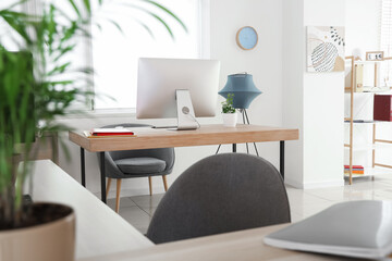 Interior of stylish office with modern workplace and lamp