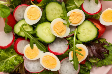 Plate of tasty salad with boiled quail eggs and vegetables, closeup