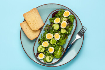Plate of tasty salad with boiled quail eggs, toasts and fork on color background