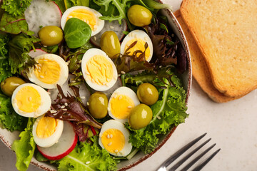 Bowl of tasty quail eggs, vegetables and toasts, closeup