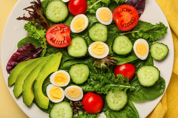 Plate of tasty salad with fresh vegetables and boiled quail eggs, closeup