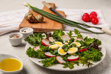Plate of fresh salad with boiled quail eggs and ingredients on light background