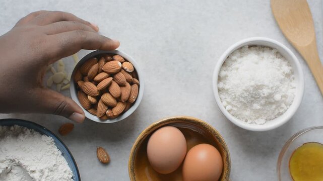 overhead view of mise en place for almond biscotti dough, ingredients for making almond cantucci cookie on a marble countertop
