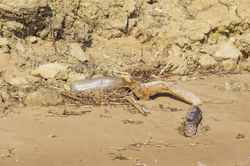 A pile of driftwood and plastic trash on a sandy beach at Sicily, Italy
