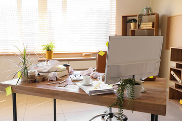 Messy workplace with computer and garbage in office