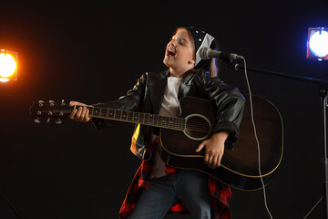 Cute little girl playing guitar and singing on stage