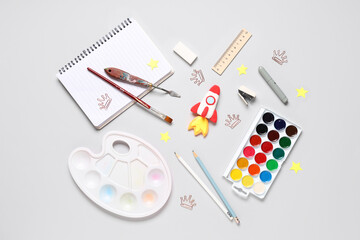 Rocket made of plasticine with different stationery on grey background. Top view