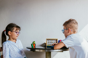 Latino children in glasses, studying and doing homework at home. Back to school. Childhood. Learning and skills