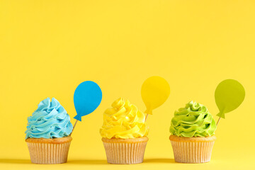 Different sweet Birthday cupcakes on yellow background